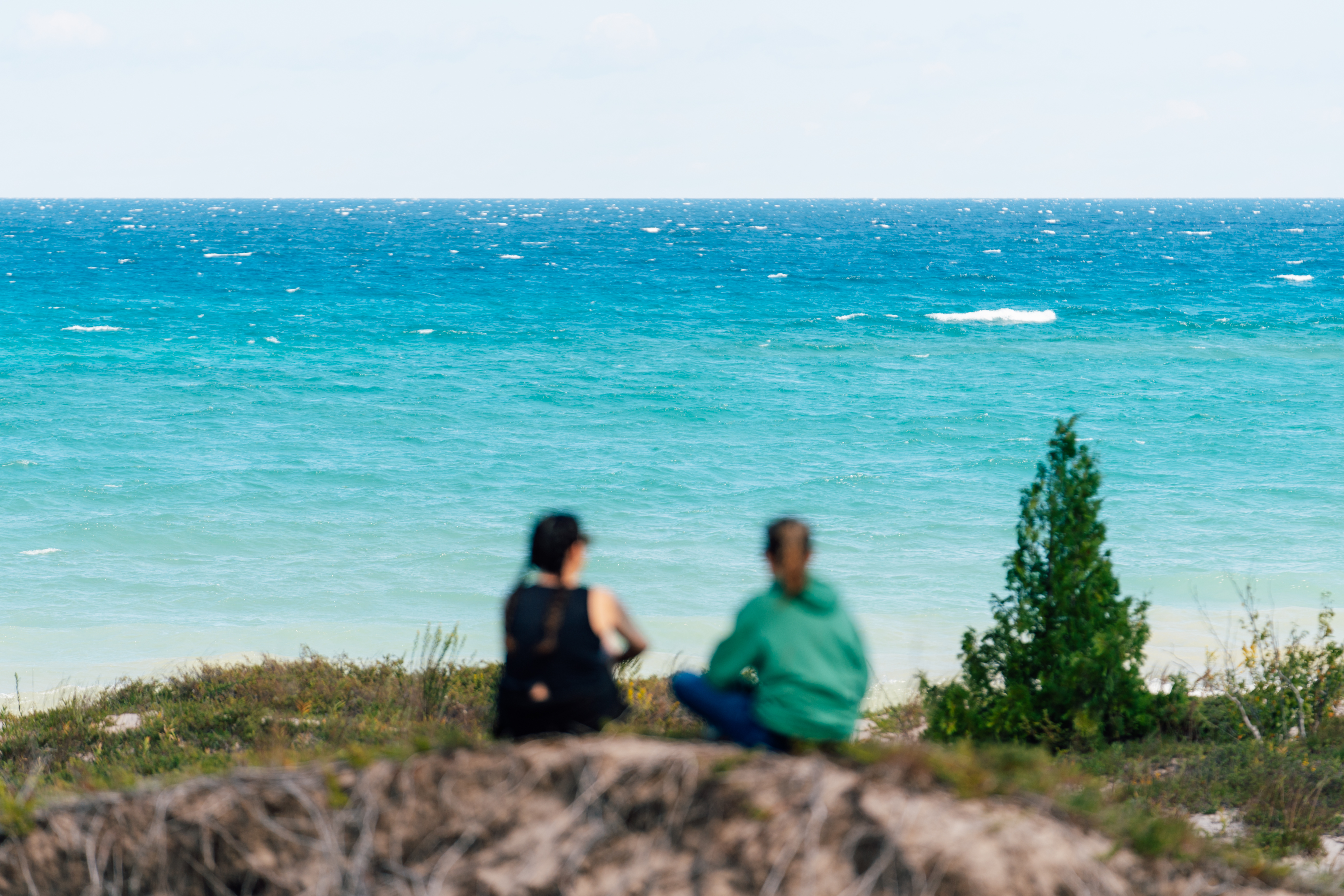 Lake Huron in Alpena Two women sitting on a sand bluff near Lake Huron