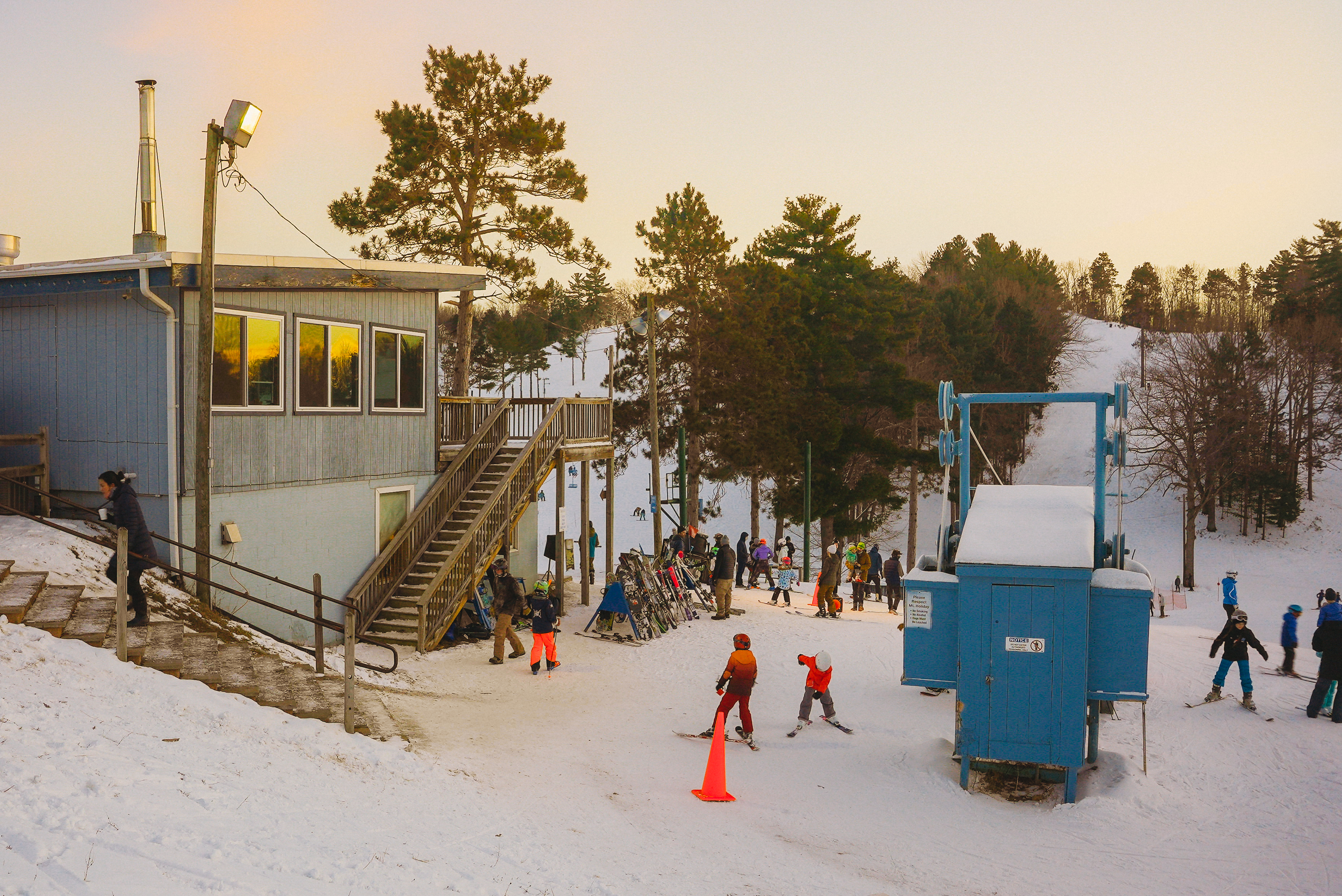 Mt. Holiday Skiiers and snowboarders walking at the base of a ski hill at Mt. Holiday