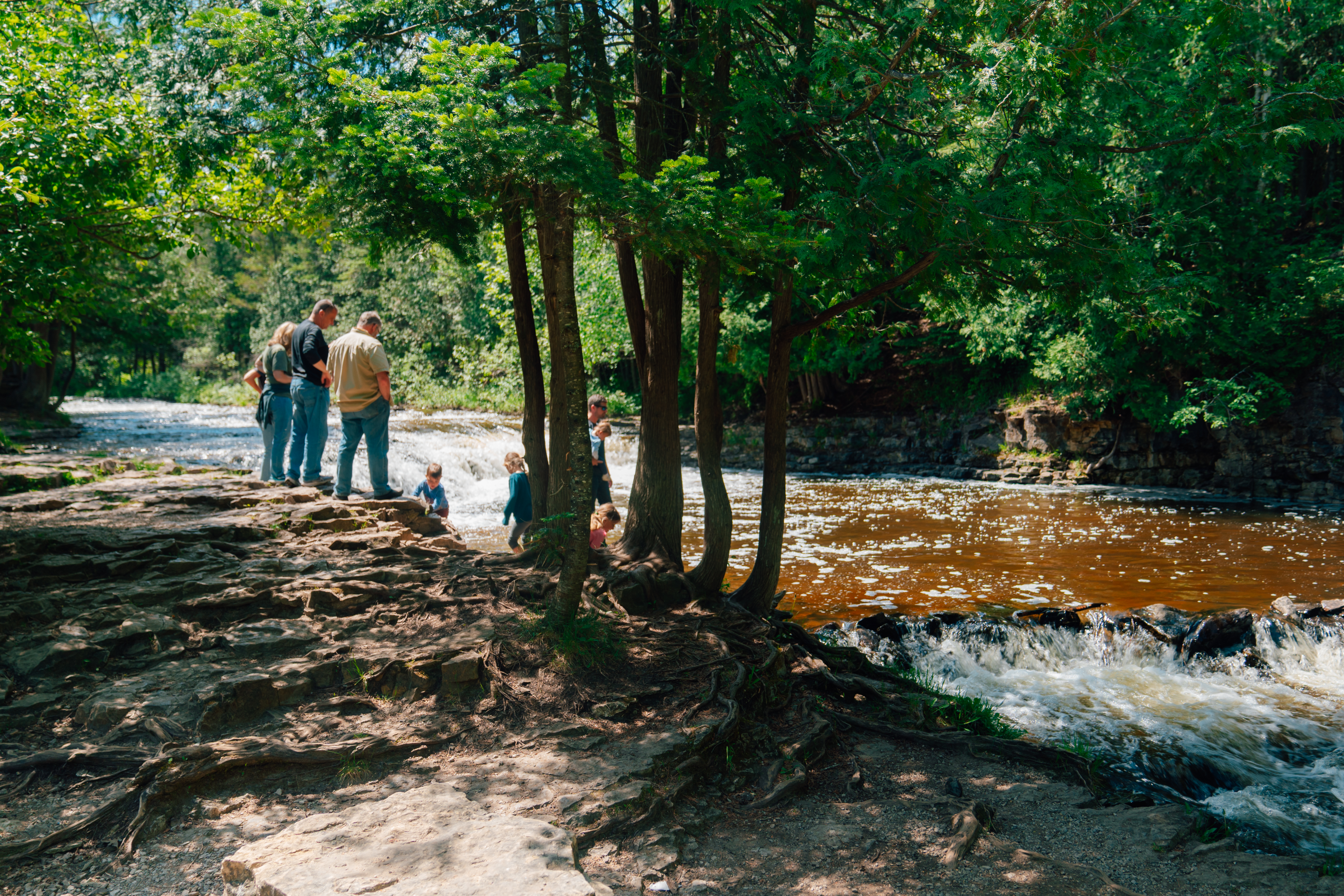 Ocqueoc Falls A family standing at the edge of the river near Ocqueoc Falls