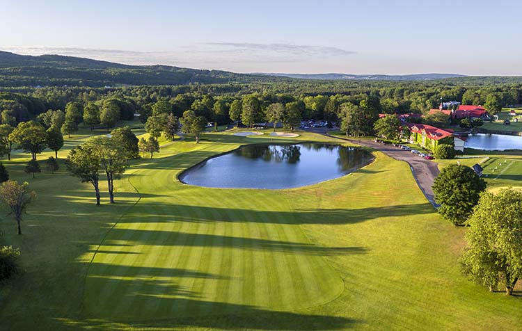 #18 on The Heather at The Highlands Lush green fairways and a large pond on hole number 18 at The Heather Golf Course at The Highlands in Harbor Springs, Michigan