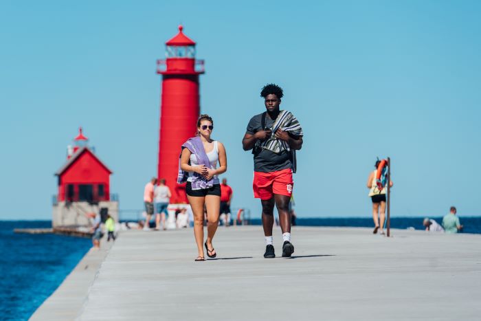 Visitors walking on the pier at Grand Haven Beach.