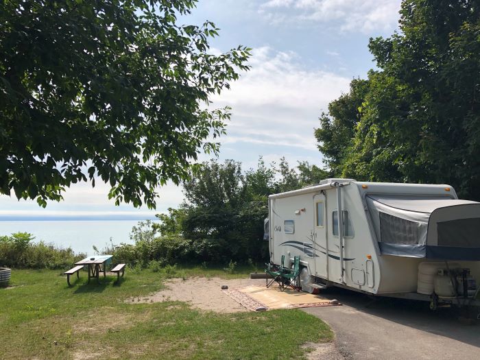 A RV camped near the shore at Harrisville State Park.